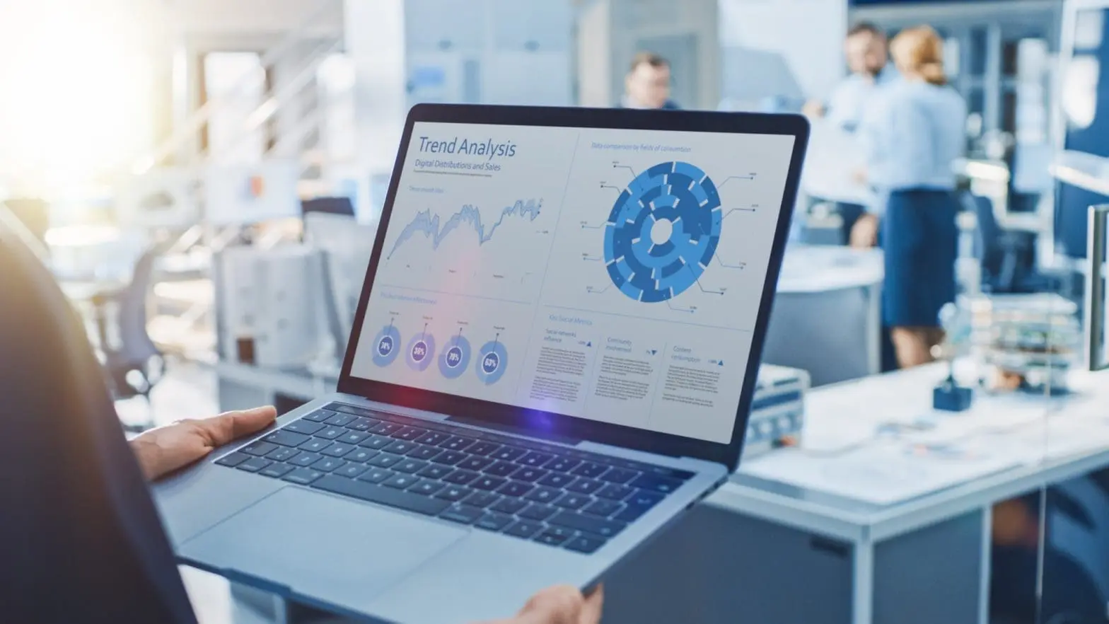Someone holding a laptop with charts, graphs of analyses of current trends.