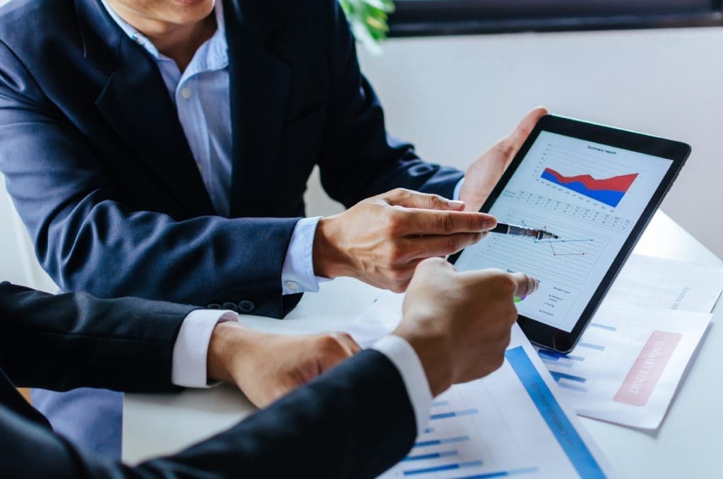 Two businessmen looking at investment graphs on a tablet