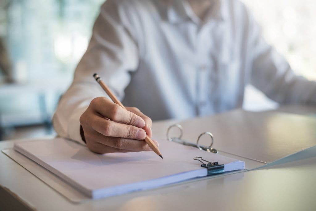 Close up of a woman holding a pencil taking notes at the office., researchers kept track of interesting findings for cold spray technology