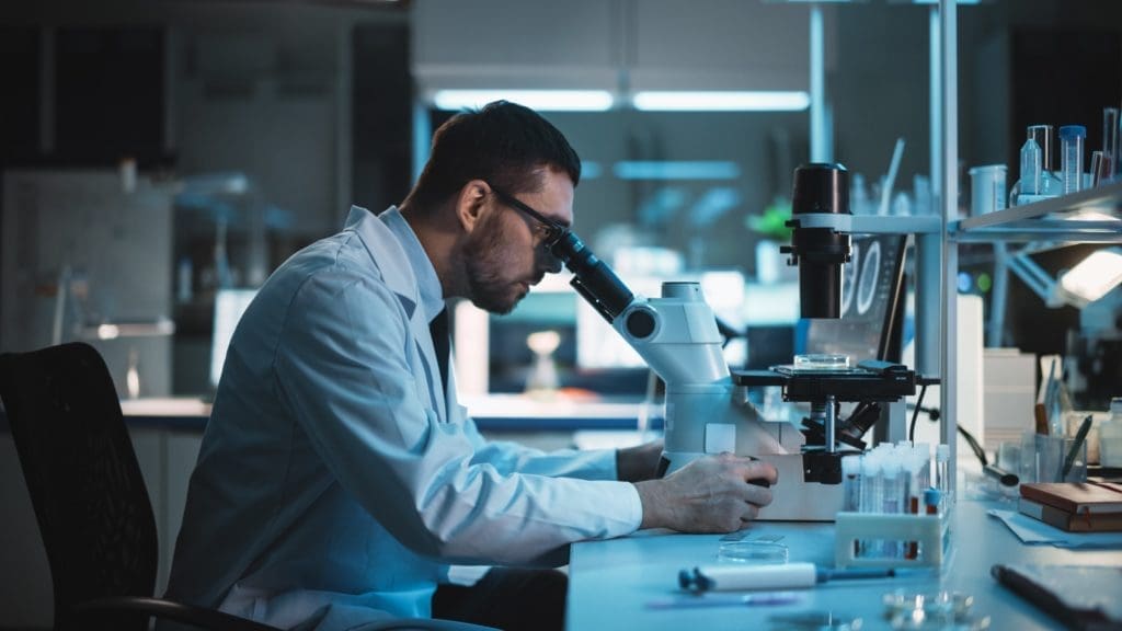 scientific research, Medical Development Laboratory: Caucasian Female Scientist Looking Under Microscope, Analyzes Petri Dish Sample. Specialists Working on Medicine, Biotechnology Research in Advanced Laboratory