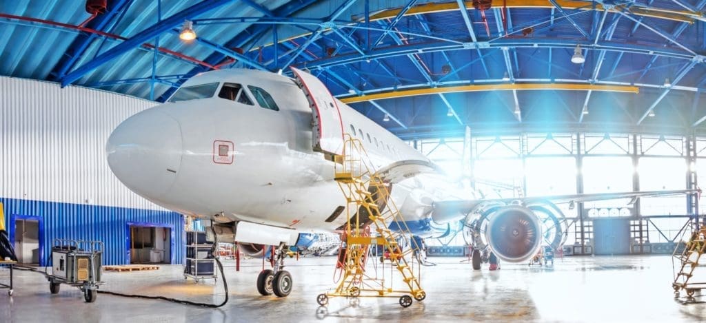 An airplane getting ready for repair in a hangar.